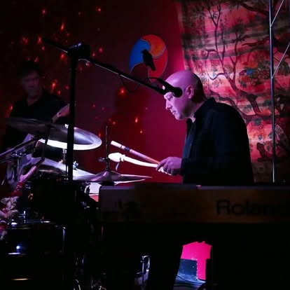Eric performing under red stage lighting