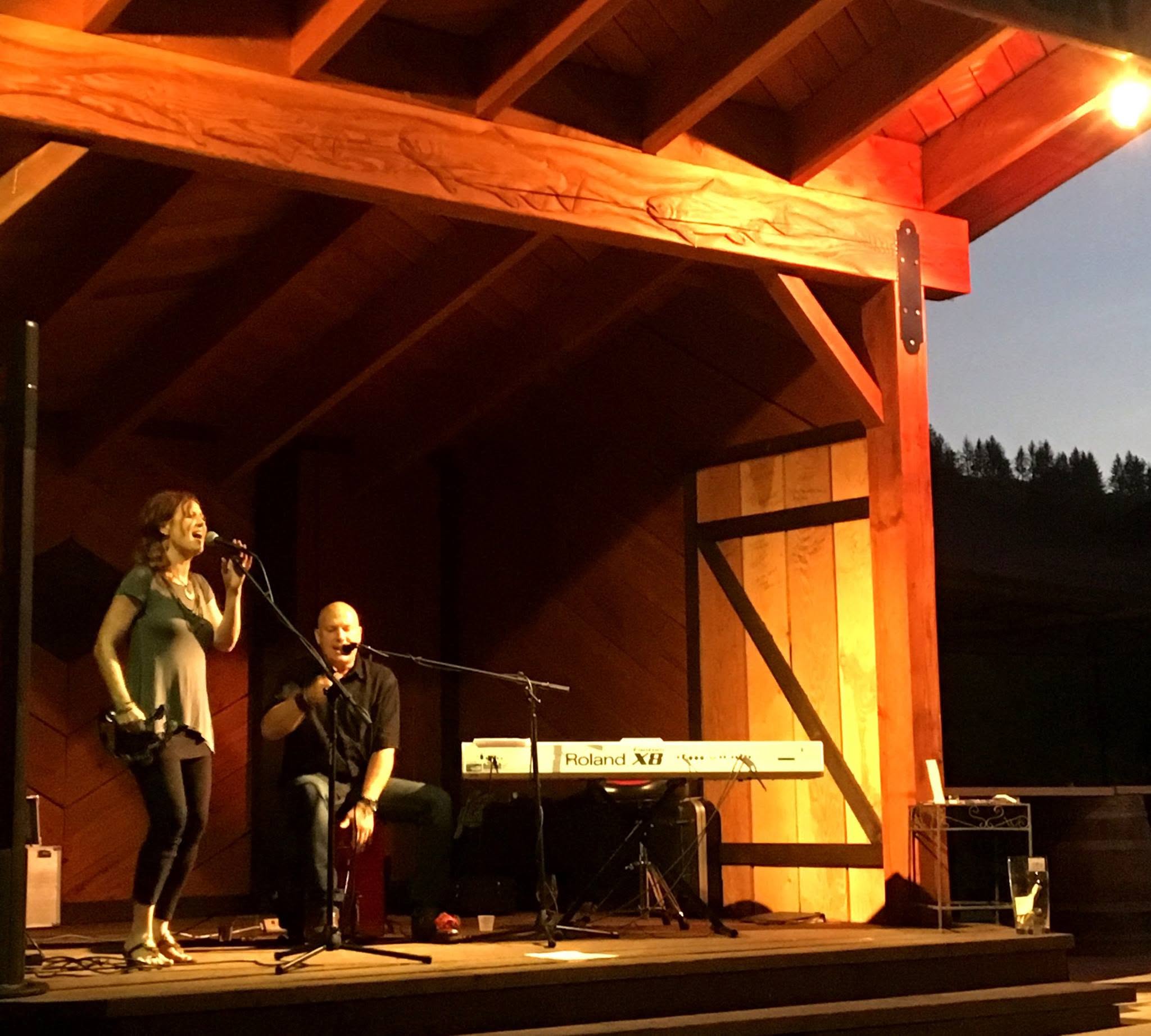 Eric and Lauri performing on an outdoor pavilion stage